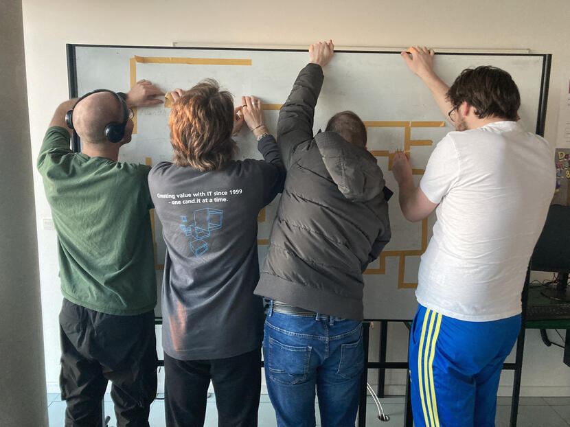 four team members removing the tape from the witheboard